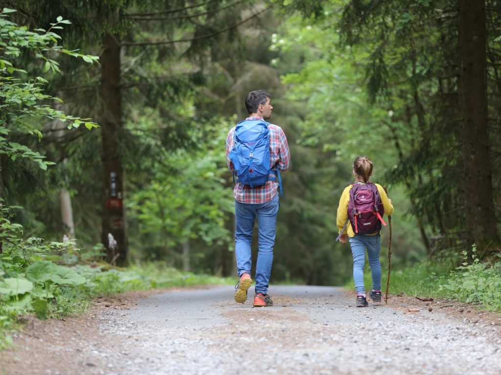 Father and Daughter hiking with backpacks on