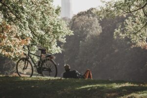 man relaxing next to bike in park