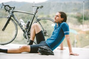 man sitting next to road bike